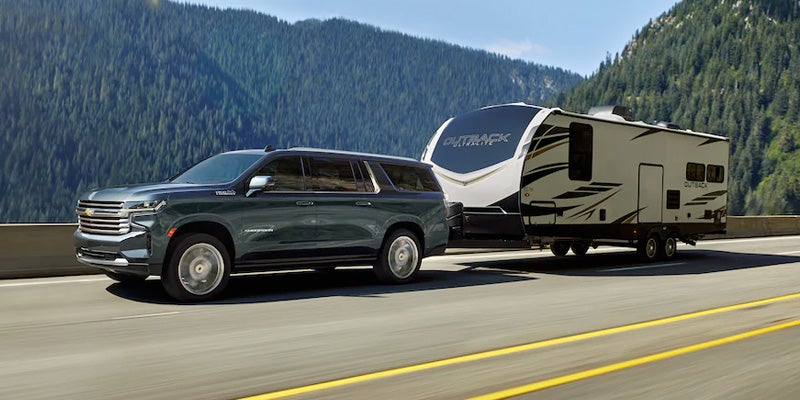 A 2022 Chevrolet Suburban towing a recreational vehicle on a highway